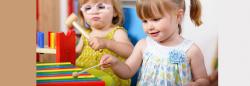 Two young girls playing with a xylophone