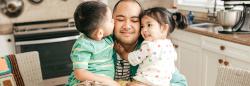 Father hugging toddler son and daughter