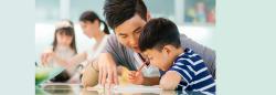 Preschooler and father writing at desk