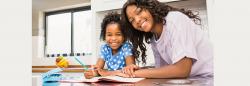 Mother and daughter at the kitchen table doing homework