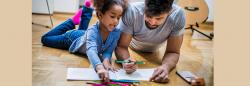 Father and daughter talking and coloring on the floor