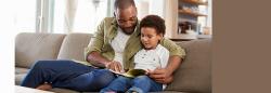 Father and son reading on couch