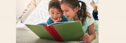 Young boy and girl read a book together