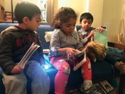 Three children reading a book