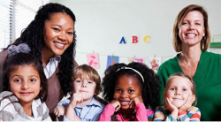 Young children and teachers smiling in the classroom