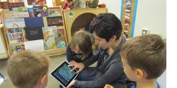 Teacher showing young children iPad