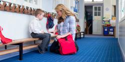 a teacher assisting a child on a bench