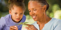 A teacher showing a child a caterpillar.