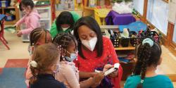 Feature Teacher Curti Dunmore reading with her students.