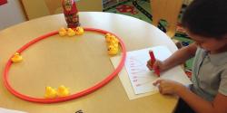 A child writing down numbers on paper.