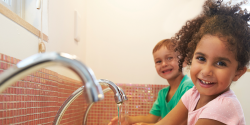 two children happily washing their hands