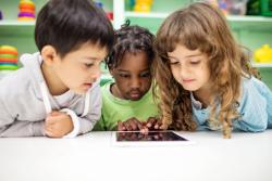 children gathered around an ipad