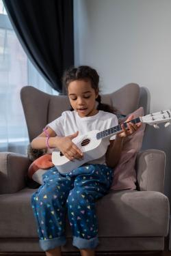 child laying ukulele