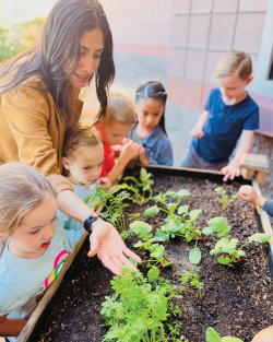 a teacher showing students a garden