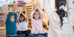 children and a teacher doing yoga poses