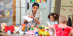 a teacher overseeing arts and crafts in a classroom