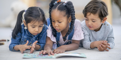 three children reading together