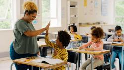 Teacher high fiving student in a classroom