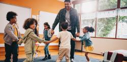 Teacher dancing in a circle with students in classroom