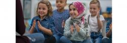 Students in a classroom smiling and clapping