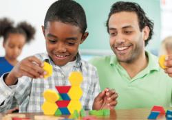 Teacher observing a child build a toy structure