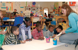 Teacher helping preschool class