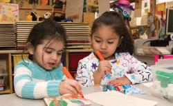 Two students drawing in a classroom