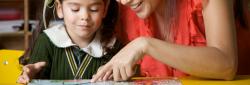 Child and teacher reading a book