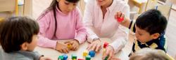 Children and teacher playing with blocks