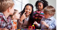 A teacher with kindergartners leading play time 