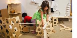 young girl putting together a 3D block puzzles using blocks