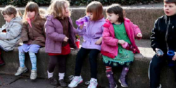 Children sitting on sidewalk