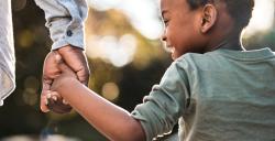 a child holding hands with an adult