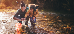 a child and parent playing in a stream