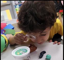 A student using a magnifying glass for a project at school