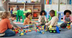Young children playing with toys and blocks on the floor in school