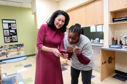 NAEYC CEO Michelle Kang showing an educator something on her phone