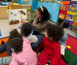 An educator reading to children in her classroom