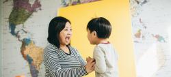 Mom and son smiling at each other with map in background