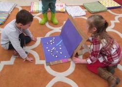 Two children creating a project with cardboard box