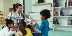 A teacher talking and engaging with a group of kids