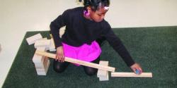 A young child builds a ramp with blocks