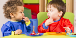 two young children eating their snacks together