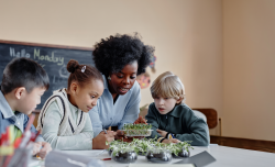 A teacher teaching students about plants in a classroom