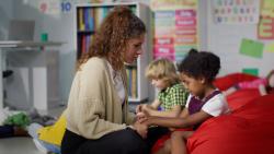 A teacher holding the hands of a student