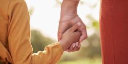 child and adult holding hands