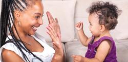 Toddler playing hand game with mother