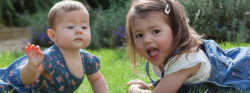 A baby and toddler playing outdoors