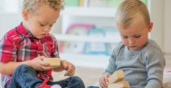 Two toddlers playing with blocks