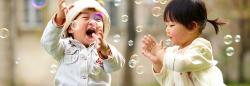 Two children playing with bubbles